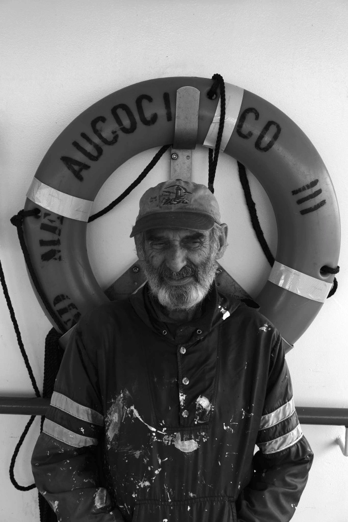 Professional maritime photograph of a sailor in front of a life ring.